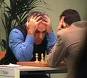 photo: Garry Kasparov and opponent over a chessboard, one holding his head in his hands. photo: Garry Kasparov and opponent over a chessboard, one holding his head in his hands.
