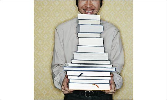 Picture of man holding an unfeasibly large stack of books. Picture of man holding an unfeasibly large stack of books.