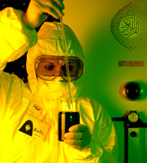 photo: person in biohazard suit and goggles using a pipette to remove liquid from a beaker photo: person in biohazard suit and goggles using a pipette to remove liquid from a beaker